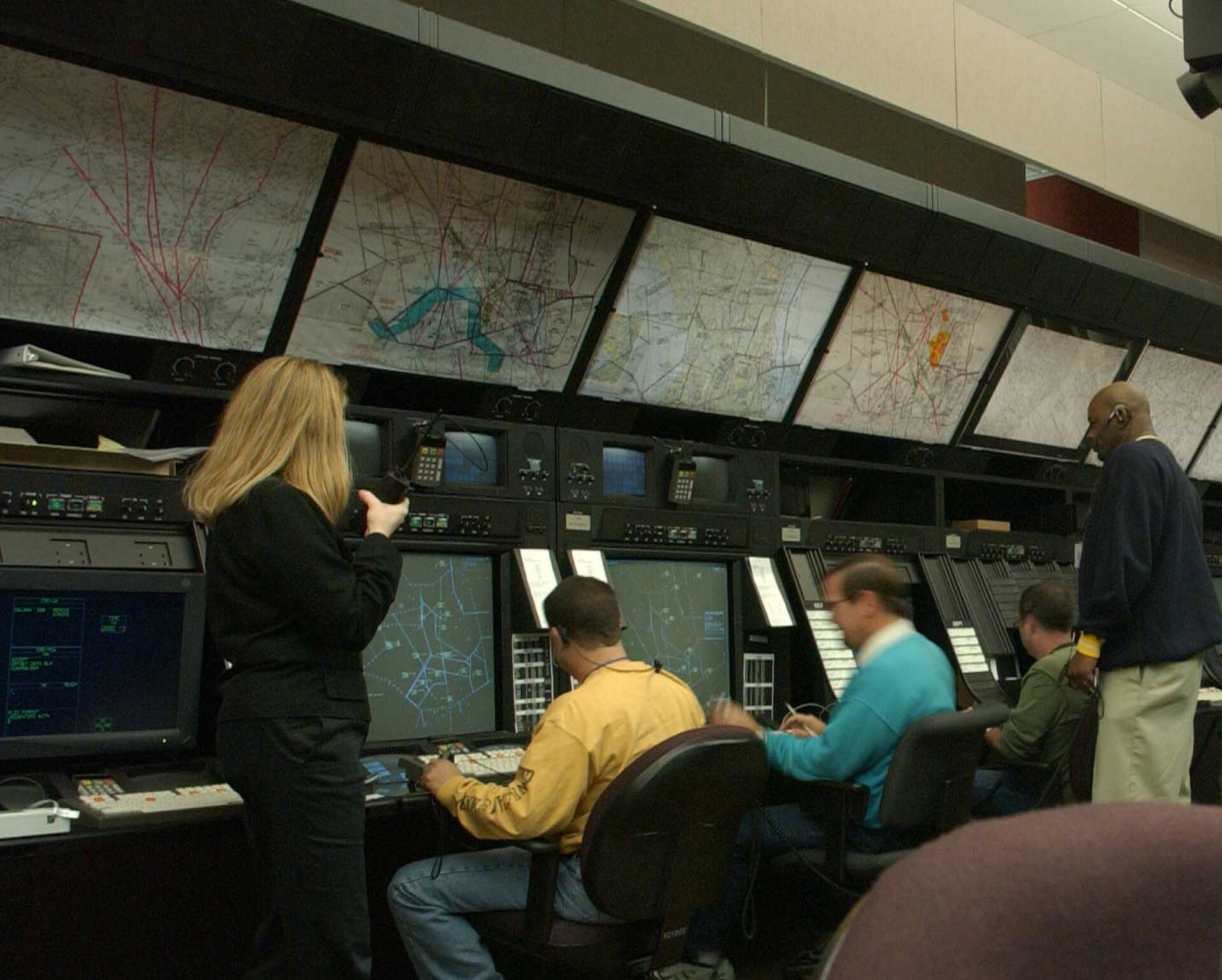 Controladores aéreos frente a pantallas de radar en un centro de control de tránsito aéreo