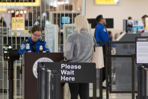 Pasajera en el control de seguridad de un aeropuerto atendida por personal de la TSA