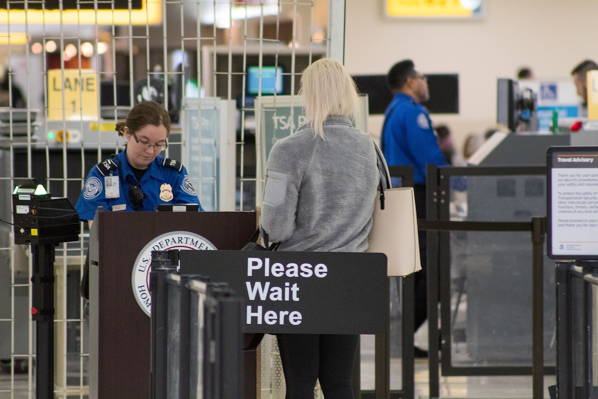 Pasajera en el control de seguridad de un aeropuerto atendida por personal de la TSA
