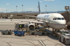 Personal de rampa cargando equipaje en la bodega de un Airbus A320 de United Airlines